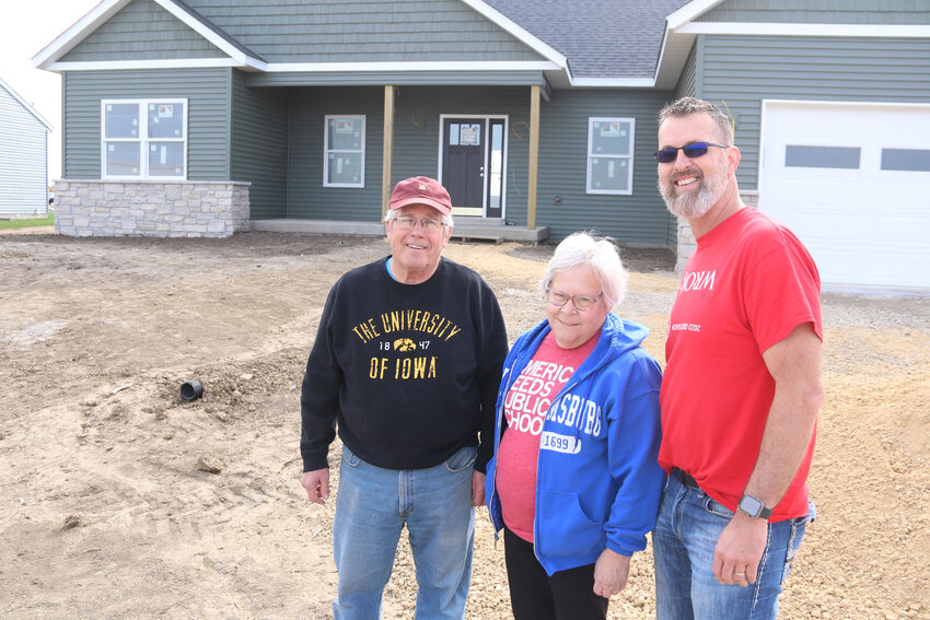 Ken and Virginia Kelly pose with student-built home coordinator James Simmons in front of their new Eldridge home.