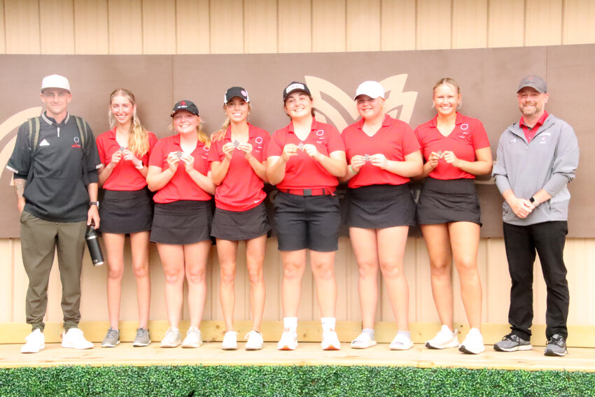 North Scott's girls' golf team poses with their medals in front of the Midland Golf Club sign. From left: Coach Collin Ellis, Adison Blevins, Kaycee Newman, Elle Loehr, Addison Eckhardt, Kalina Stoefen, Mya Ruyter, and Coach Zeb Hubner.