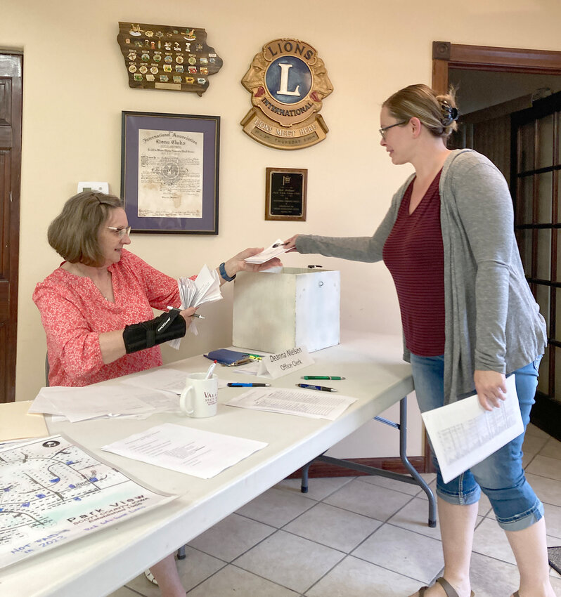 Park View Owners Association secretary Deanna Nielsen accepts a ballot at the association's annual meeting May 17.