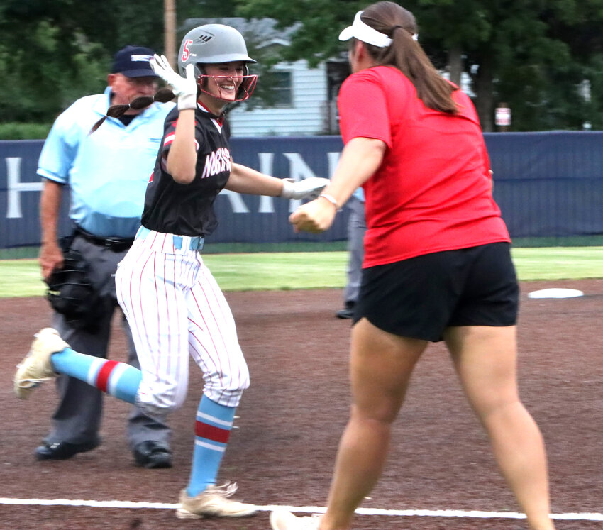 Lancer senior Teagan Kelley gives coach Holly Hoelting five after blasting the home run that started North Scott's seventh-inning rally.