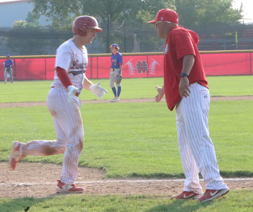 Noah Young gives co-coach Brad Ward five after hitting a home run against Central.