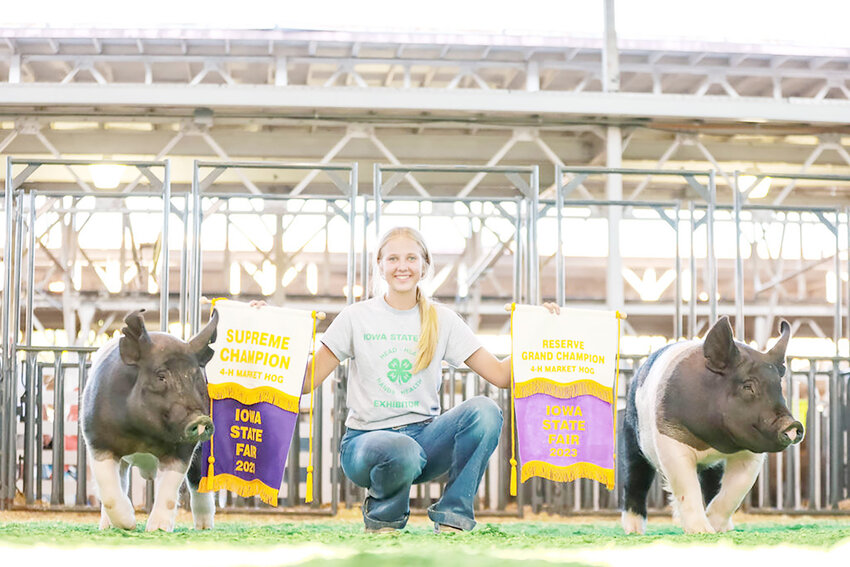 Rilynn Buesing poses with the supreme champion and reserve at the Iowa State Fair.