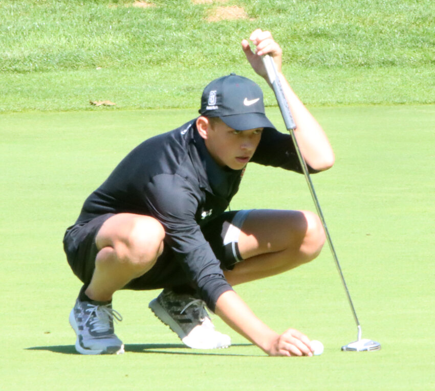 Senior Keaton Kress lines up a putt at Palmer Hills Golf Course.