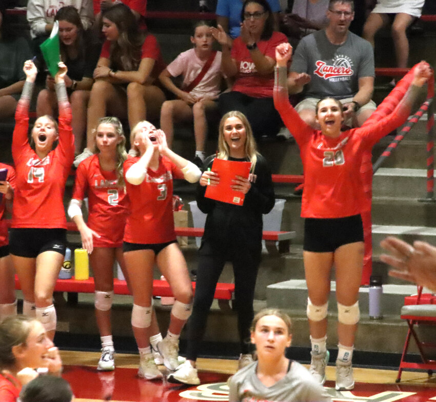 Lancers Kira DeCastecker (14), Taylor Oetzmann (2), Laina Brehmer (3) and Paige Coon (20) celebrate after the Lancers convert set point in the second set.