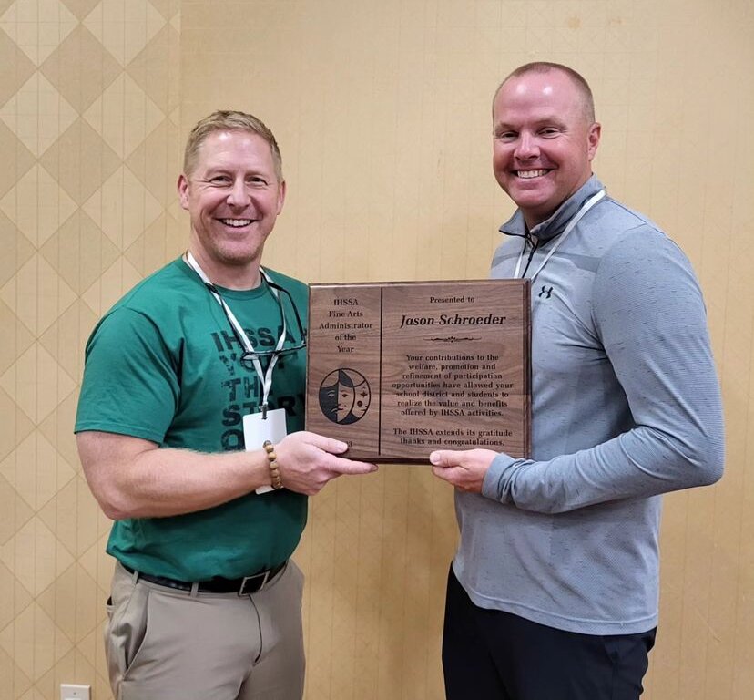 Jason Schroeder accepts the Fine Arts Administrator of the Year award  from Kevin Seney, of the Iowa High School Speech Association executive Board and principal at Grinnell High School.