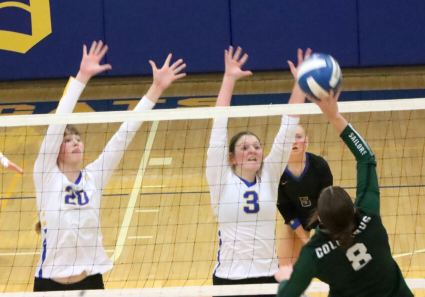 Katelyn Toft (20) and Layla Streeter (3) rise up to block Natalie Steele's (8) kill attempt.