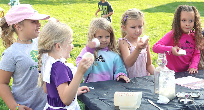 Lyla Kuhl, Olivia Lewis, Emily Havener, Evelyn Nagle-Kuch and Tatianna Rhodes shake containers of cream to make butter.