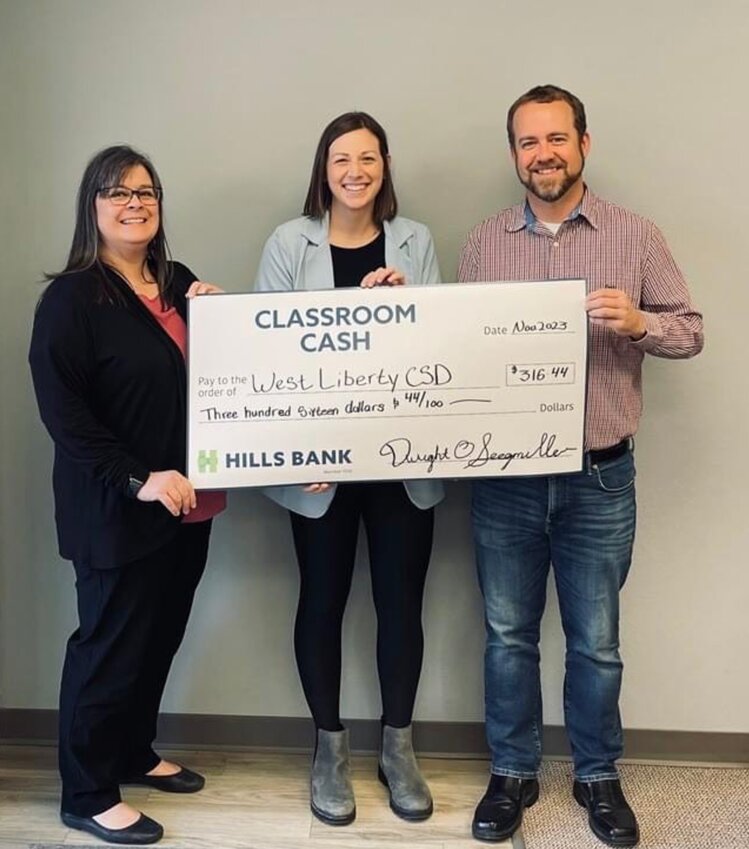 Renee Harned (left) and Lars Underbakke (right) with Hills Bank presenting Abby Ortiz West Liberty Business Manager with their Classroom Cash Check for $316.44. Contributed photo