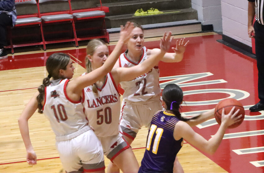Bella Mohr (10), Madison Wilshusen (50) and Mercie Hansel (22) create a sea of hands in the face of Saber ballhandler Clara LeConte during Friday night's game.