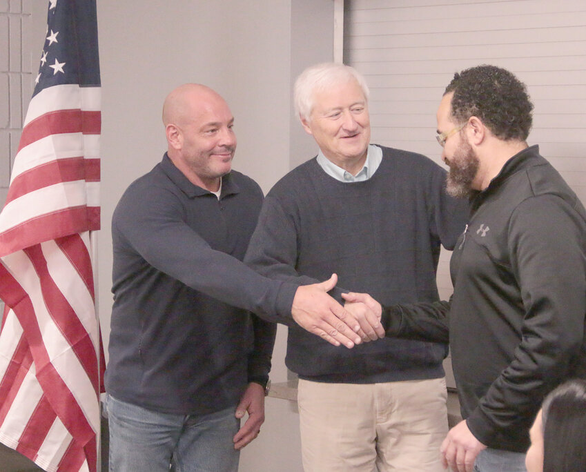 New Eldridge council members, from left, Ryan Iossi, and Scott Campbell, greet reelected incumbent Adrian Blackwell at the Jan. 2 council meeting, where all were sworn in for new terms.
