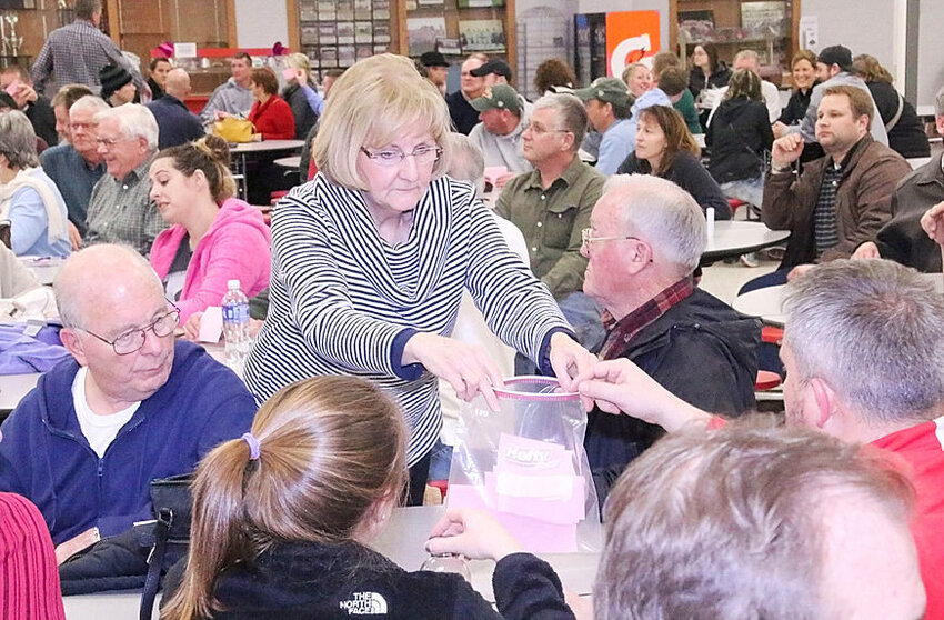 Lynette Johnson collects Republican caucus presidential ballots at the 2016 GOP caucus at North Scott High School.