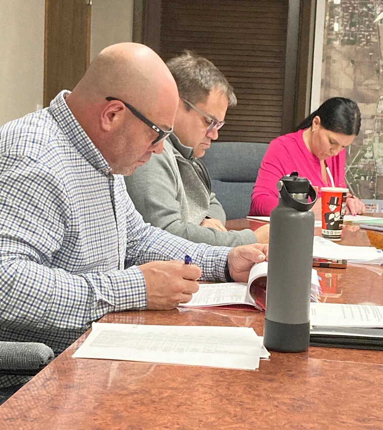 Council members Ryan Iossi and Dan Collins, and administrator Nevada Lemke pore over spreadsheets at a Jan. 29 budget meeting.