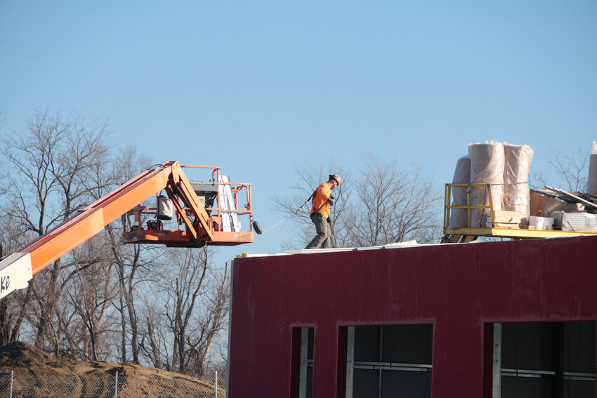 Russell Construction crews and contractors assemble a roof and wall panels at the North Scott school districts vocational center under construction on South First Street.