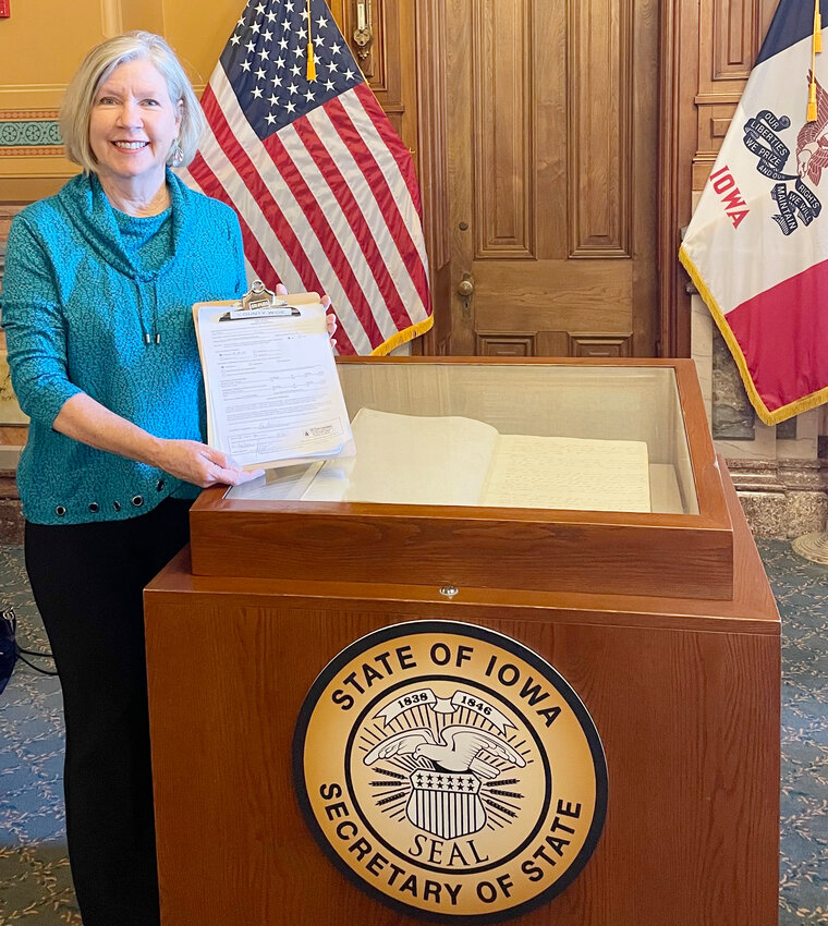 Kay Pence, of Eldridge, poses with her candidacy petition at the Iowa Secretary of State's office.