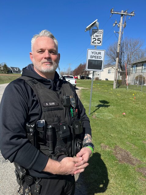 Wilton Police Chief Dave Clark stands in front of one of the solar-powered speed signs on West Third Street, which will help slow down traffic in the neighborhood