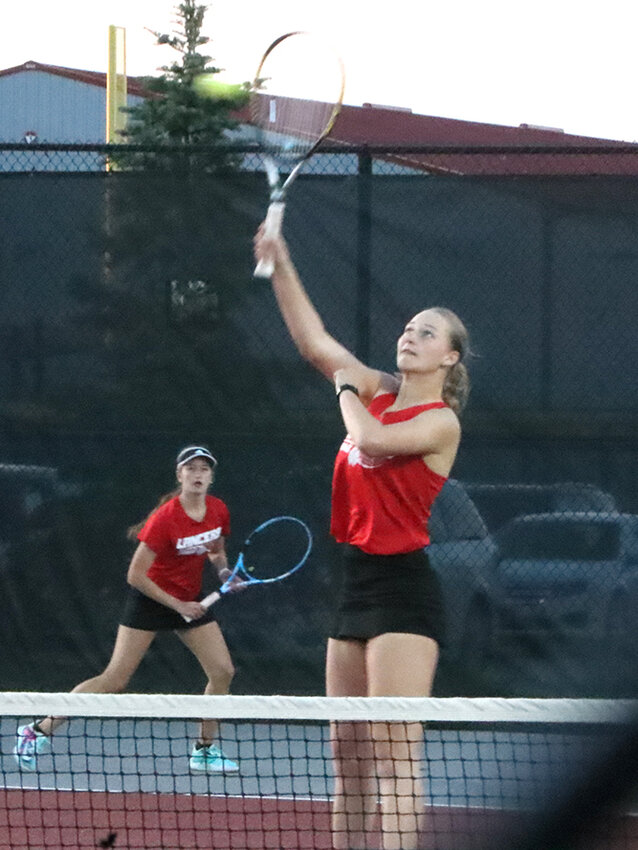 Senior Madison Wilshusen goes up for a smash in her doubles match with junior Sydney Groene.