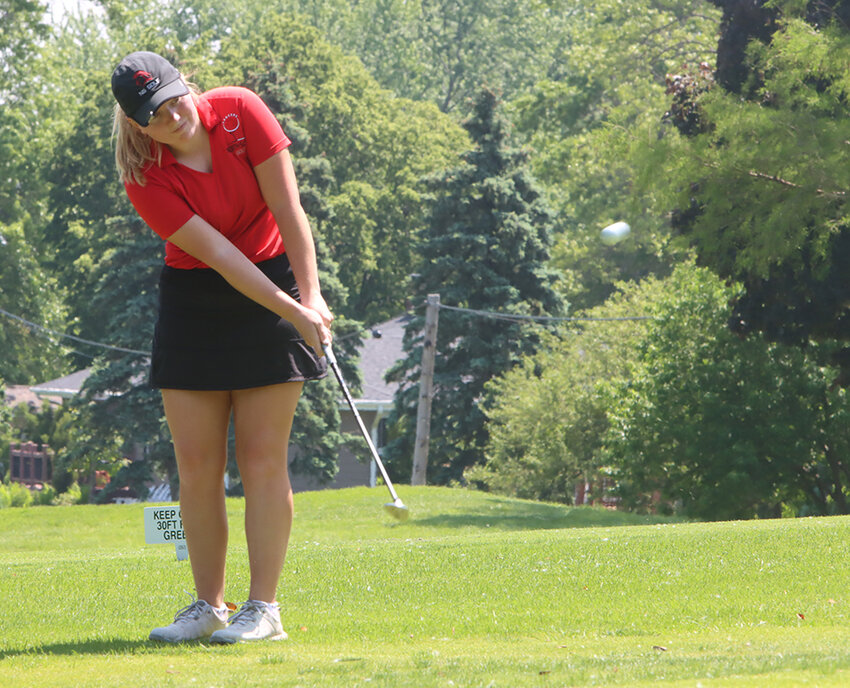 Senior Kaycee Newman chips onto the green as she starts the front nine at Geneva Golf and Country Club.