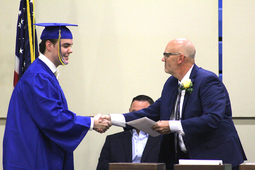 Tyler Garcia receives his diploma on stage during graduation at Wilton High School