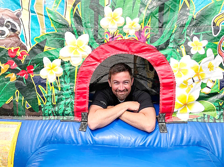 Hy-Vee&rsquo;s Andy Lane relaxes in the bounce house brought in for his going-away party Saturday in Eldridge.
