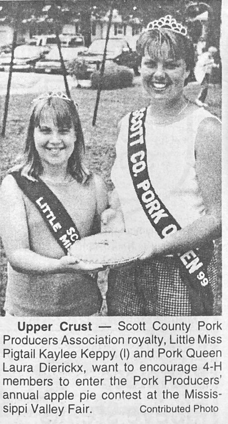 1999: Scott County Pork Producers' Little Miss Pigtail Kaylee Keppy, and Pork Queen Laura Dierickx invite Mississippi Valley Fair fans to enter the pork producers' apple pie contest.