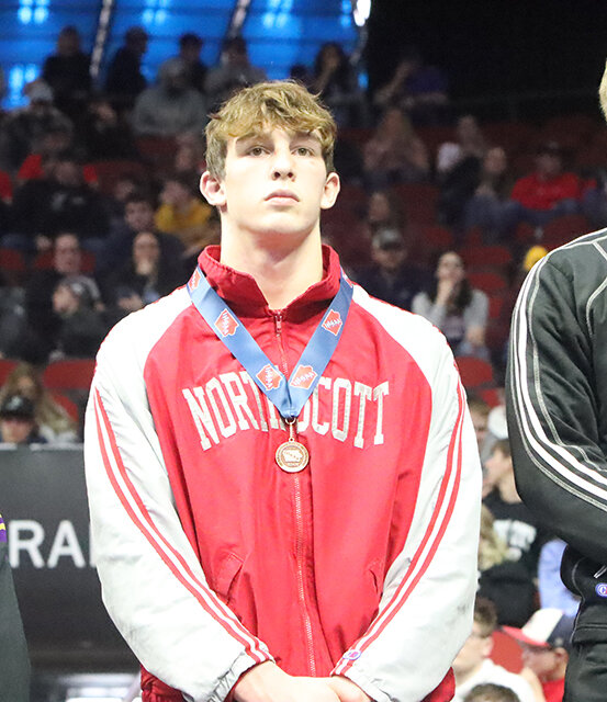 Trey Feist stands on the podium with his fifth-place medal.