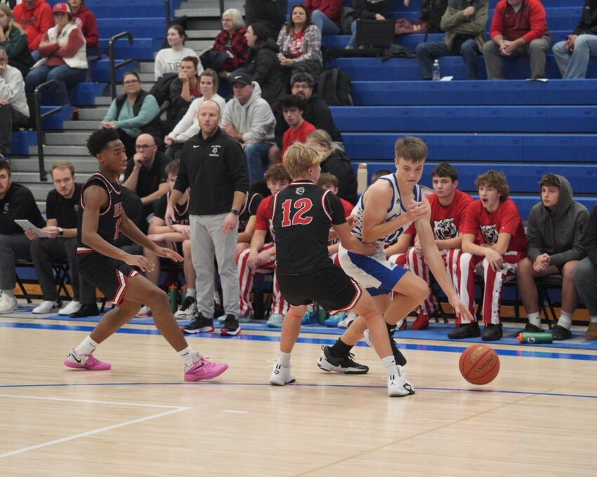 Comet senior Cole Daufeldt dribbles around a pair of defenders.