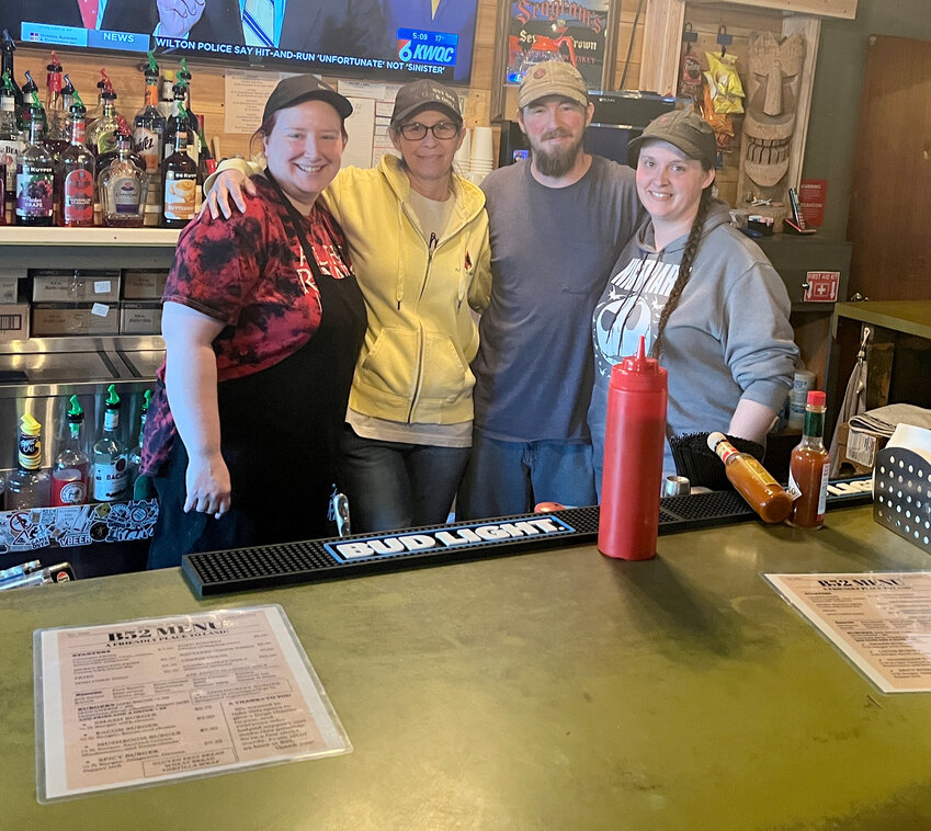 B52 employees Jess Wickersham and Kelly Baker pose with owners Kyle Neuzil and Malynda Woodside behind the bar. The group has made the establishment family friendly and is continuing to grow their restaurant business.