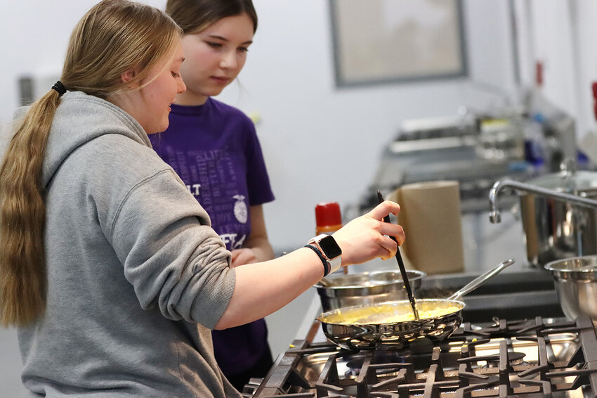 Aaliyah Shimkus and Amelia Bunce scramble some eggs.