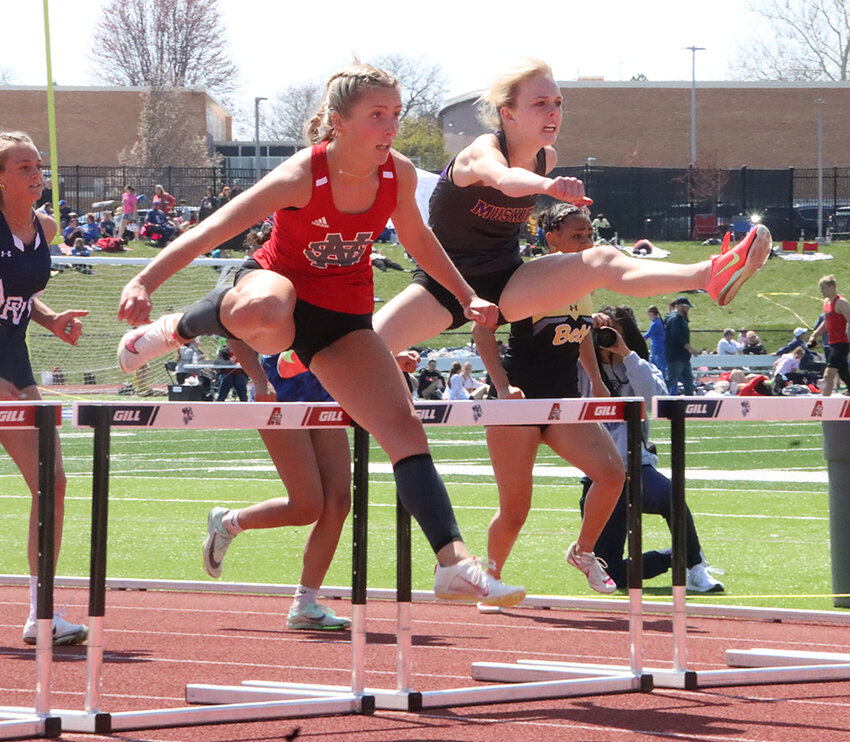 Lancer senior Chloe Morrison battles Muscatine's Avery Bradley in the 100-meter hurdles on Saturday at the Assumption Invitational.