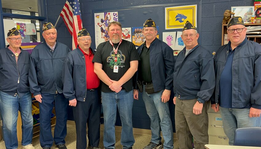 American Legion members Commander Ray Arp, former department commander Ken Rochholz, Colorguard Commander Roger Howe, Scott Wolf, Memorial Day Coordinator Greg Fenerbach, and Committee Chair Jim Walker present stand with Durant teacher Mark Abels.