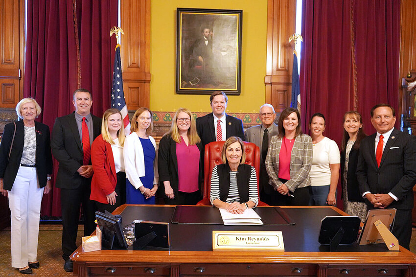 Scott County auditor Kerri Tompkins (fourth from left) joined other county auditors and Secretary of State Paul Pate as Gov. Kim Reynolds signed two bills relating to elections on June 2.