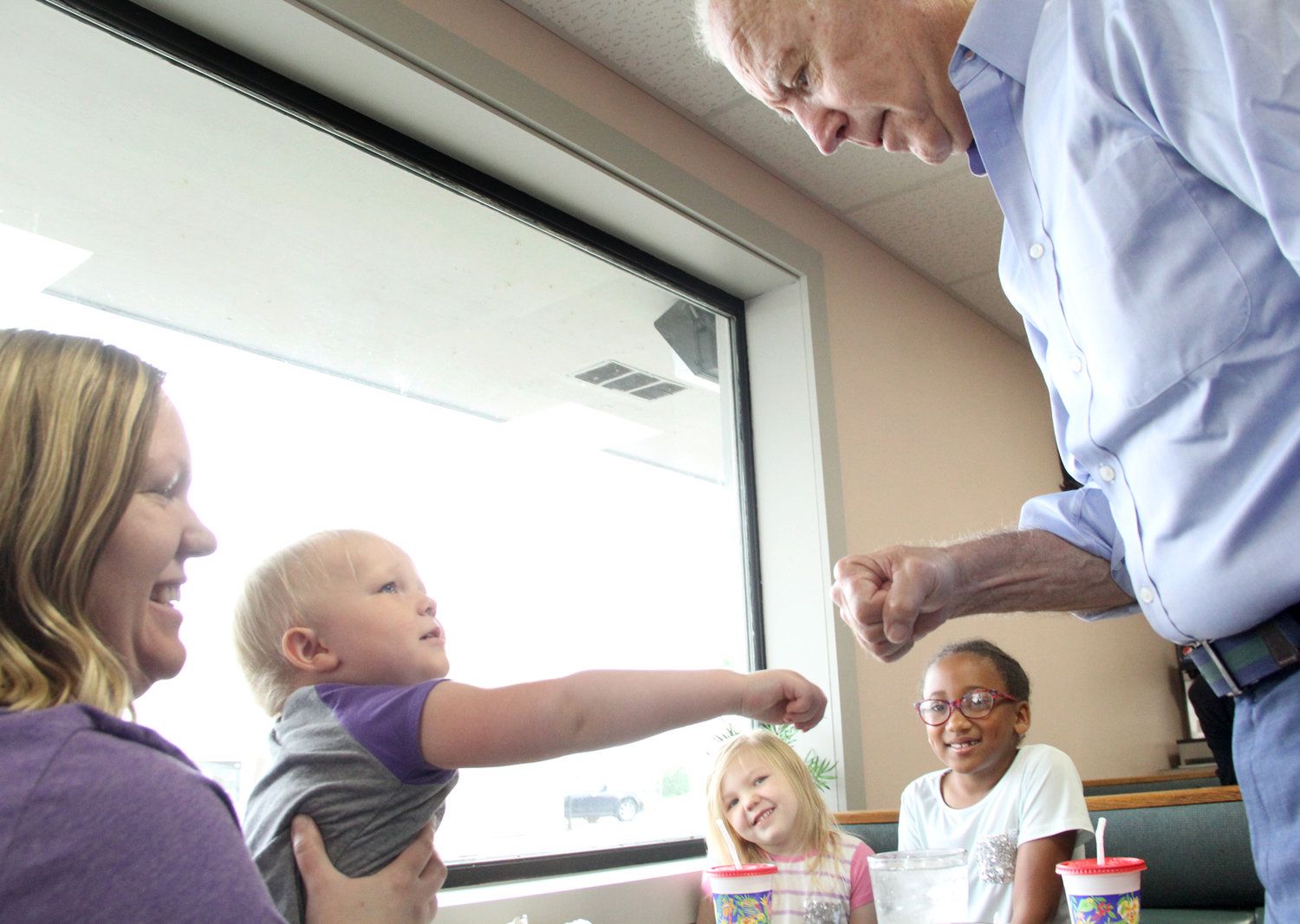 Joe Biden fist-bumps 2-year-old Hannah Bowers, with her mom, Abby, and sisters Miriam and Cleo Thursday at the Tasty Cafe.