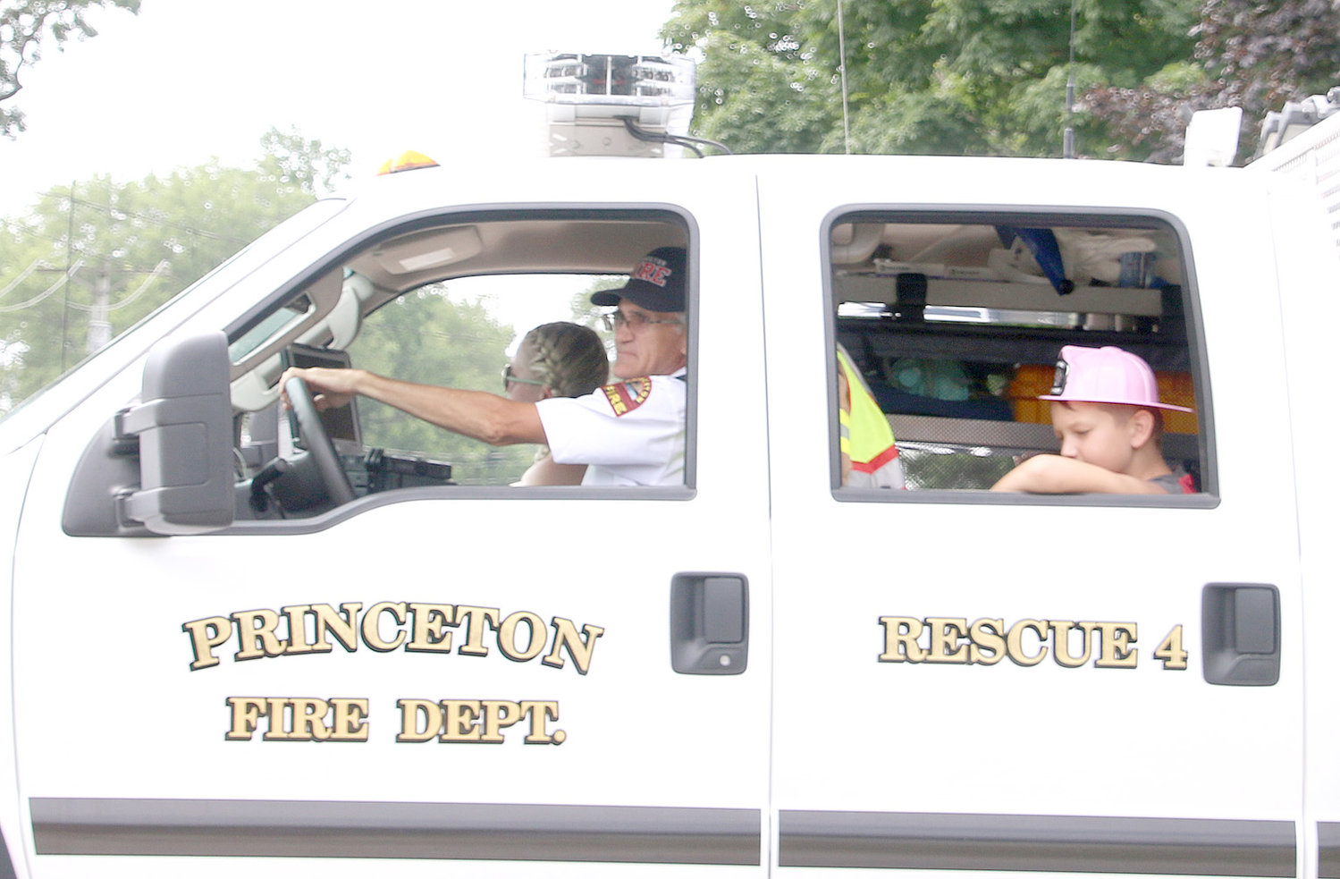 Assistant Fire Chief Daniel Doyle, left, and Colton Gentz, lead a squadron of fire trucks through the parade.