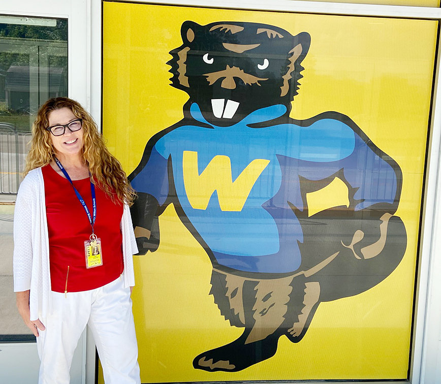 New Wilton 7-12 Principal Sue O'Donnell is pictured next to the new entrance to the Wilton High School Townsend Commons, which will open the first day of school Aug. 25, and features new logos and signage like the vintage Beaver mascot pictured.