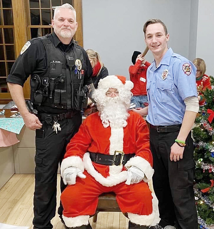 Wilton Police Chief Dave Clark (left) is pictured at Wilton City Hall with Santa and his son Daryn Clark during Wilton's Shop with a Cop event Dec. 16. Daryn was in a serious car accident Dec. 19, and has been in the hospital in Iowa City since.