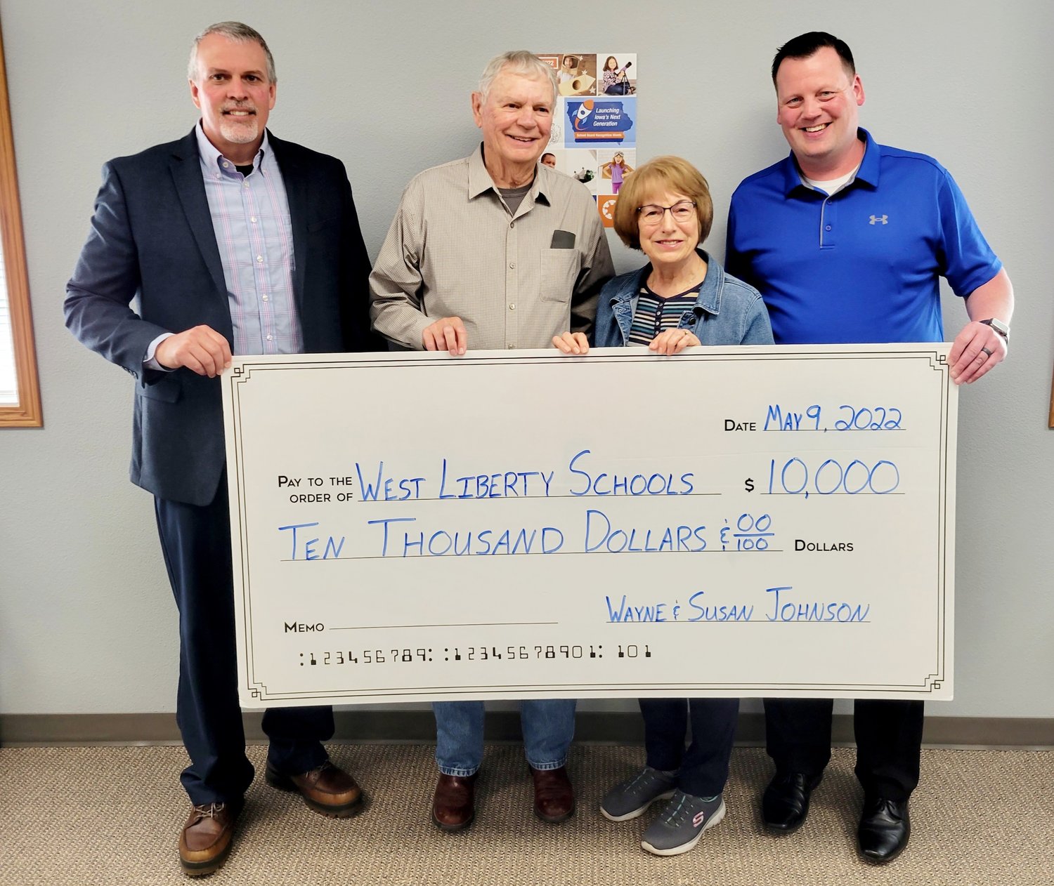 Former WLHS track coach Wayne Johnson and his wife, Susan, have pledged $10,000 towards the new sports complex. Accepting the check is Superintendent Shaun Kruger, on left, and Activities Director Adam Loria, right.