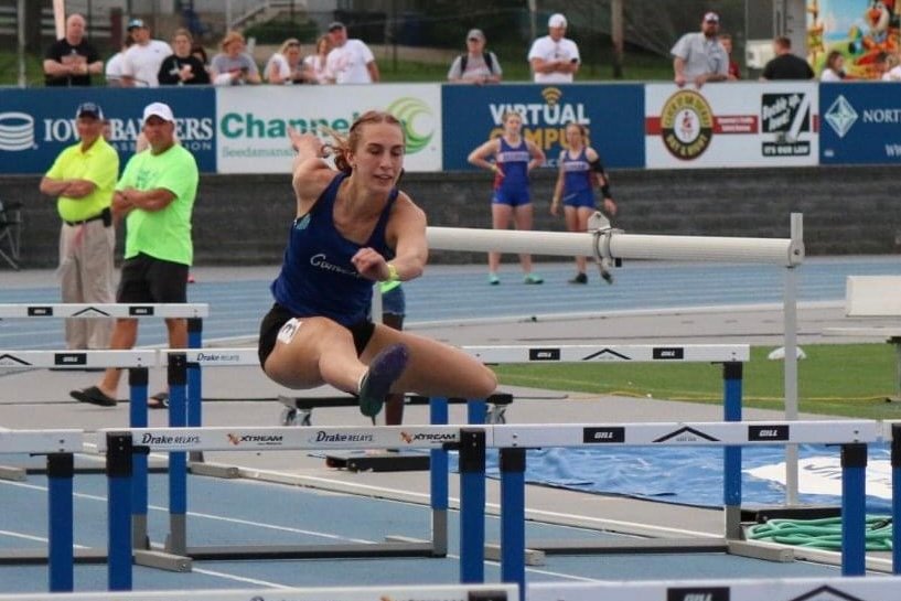 Maci Daufeldt works her way over a hurdle during the 4 x 100 relay at the state track meet last week. The girls track team took third place in the event.