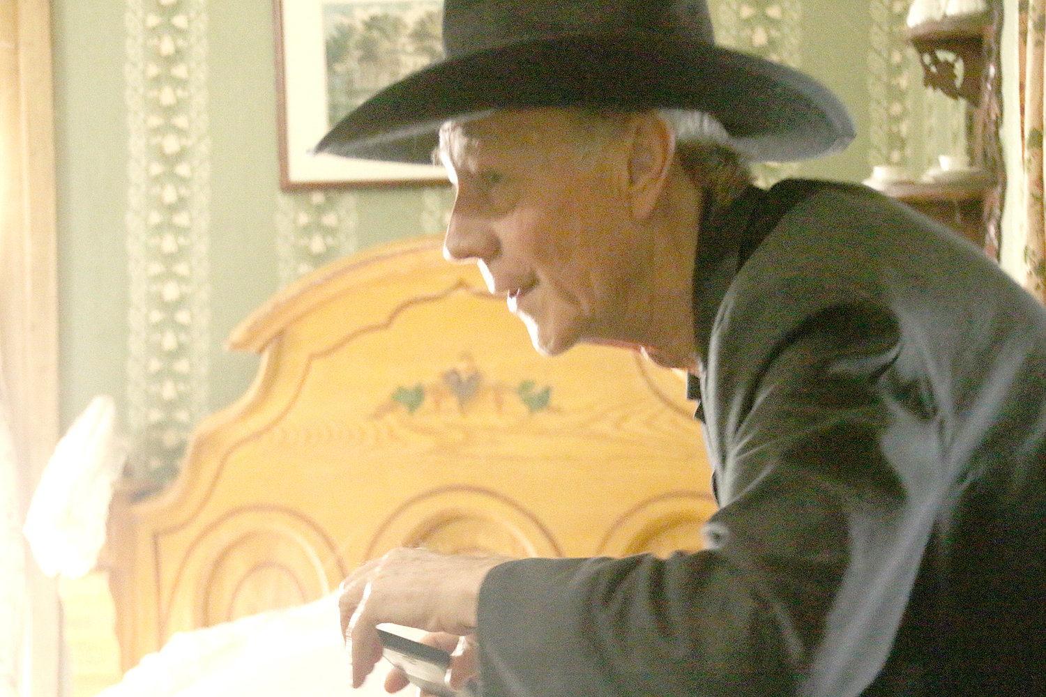 Allan Cody snaps a photo in a Cody Homestead bedroom.