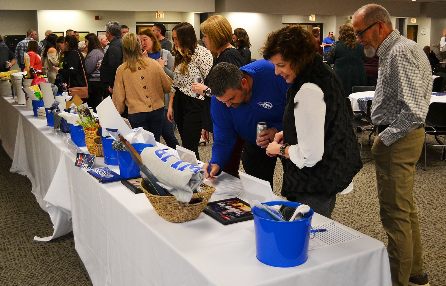 Comet Gala attendees look at the silent auction table at the West Liberty Community Center Saturday, March 4.