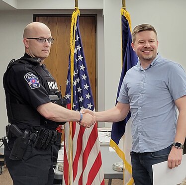 West Liberty's newest police officer Don Strong shakes Mayor Ethan Anderson's hand after being sworn in at the city council meeting Tuesday, May 16.