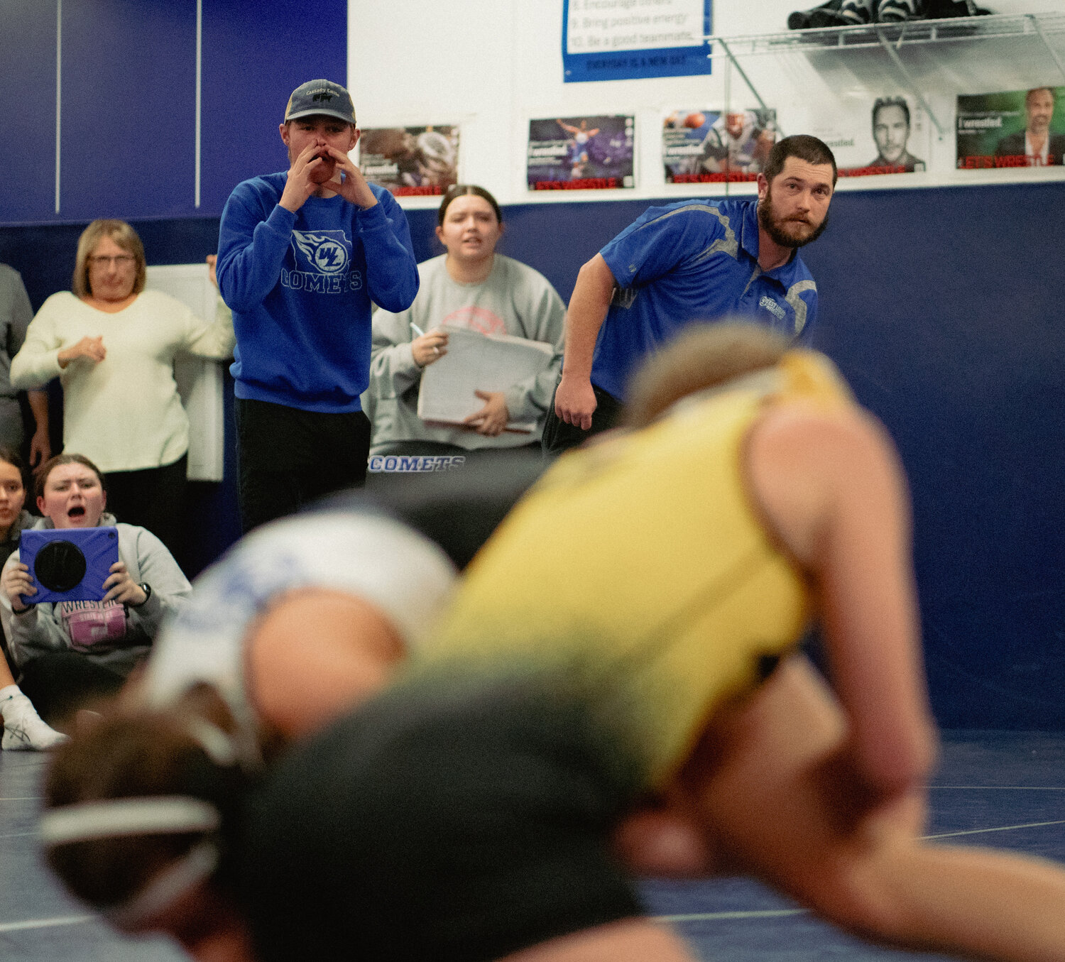 Coaches Colin Cassady (left) and Dillon Christensen look on from the coaches' corner in at Mat 3 in the Comets' wrestling room.