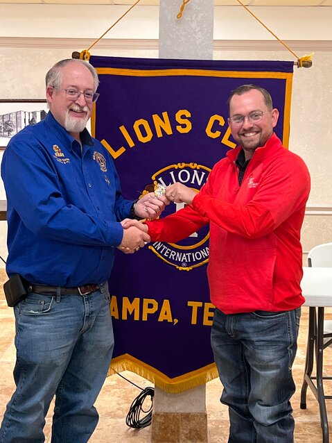 Roger Estlack, Lions Club District Governor presents Cade Taylor with a pin