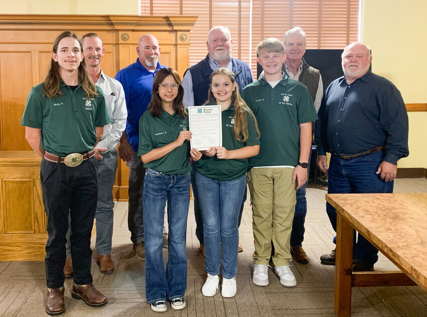 4-H members Nicky Price, Angelique Ritchie, McKinley Clark and Gavin Greer stand with the commissioners and Judge Porter