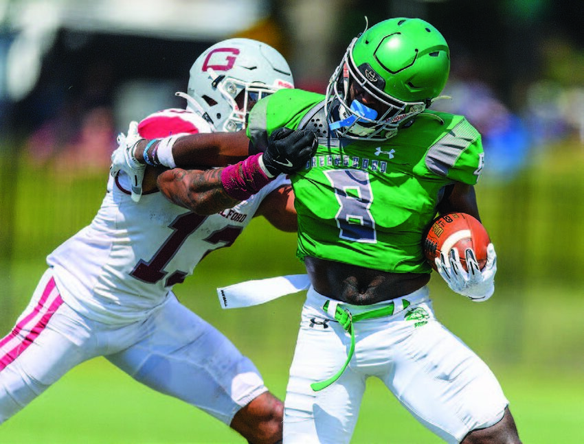 Guilford College DB Malik Hargrove (#13) tries to make the tackle against Greensboro College WR Mandre Ogletree (#8).