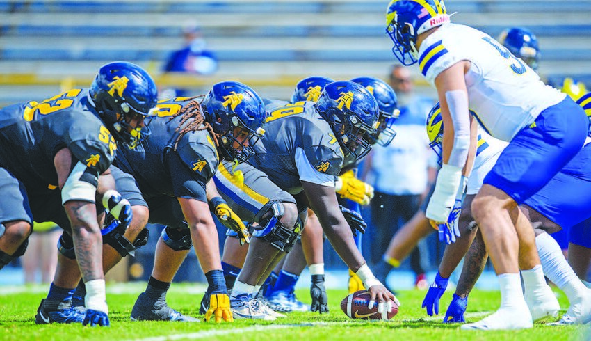 The A&T offensive line (left) goes head to head with the Delaware Blue Hens’ defensive line.