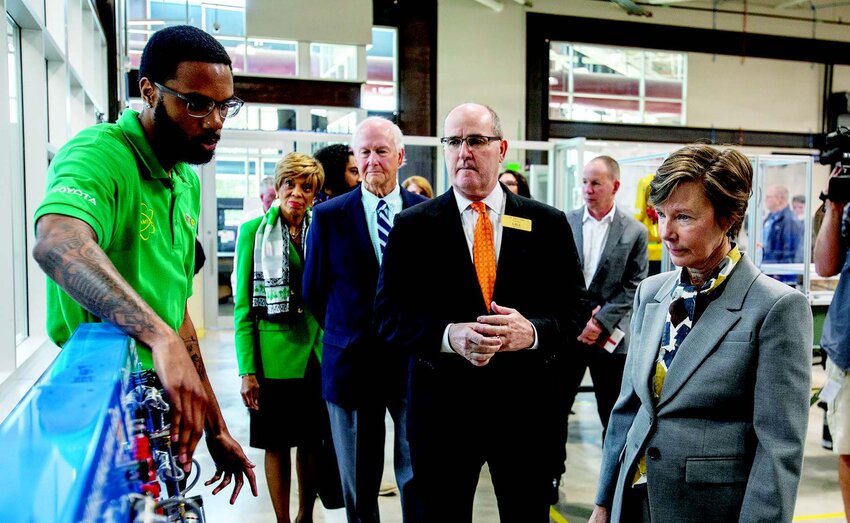 Student Jalen McNairy explains a control board to N.C. Lt. Gov. Rachel Hunt, center, with GTCC President Dr. Anthony Clarke, center left.
