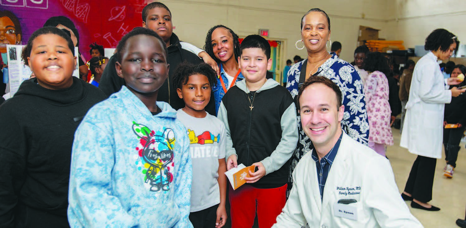 Duke University Family Medicine physician Dr. William Bynum, right, meets with Bessemer Elementary students and Tanya Dixon, top right, a Bessemer Elementary school counselor and Career Day organizer
