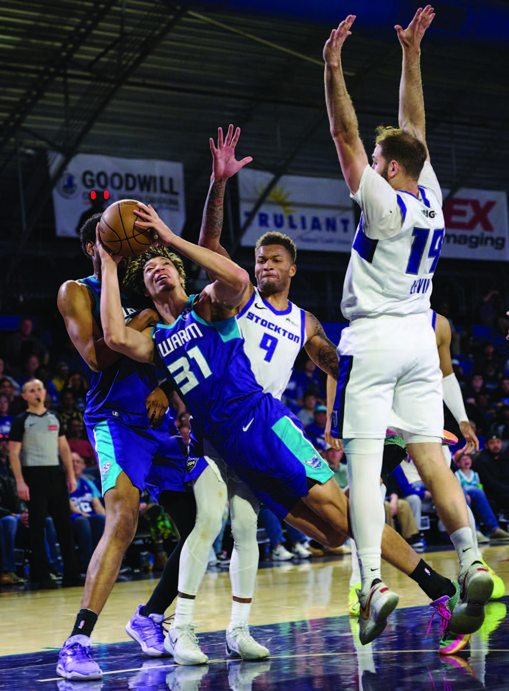 The shot of Greensboro Swarm forward Tidjane Salaun (#31) is contested by Stockton Kings guard Dexter Dennis (#9) and forward Gabe Levin (#19) during this NBA G League