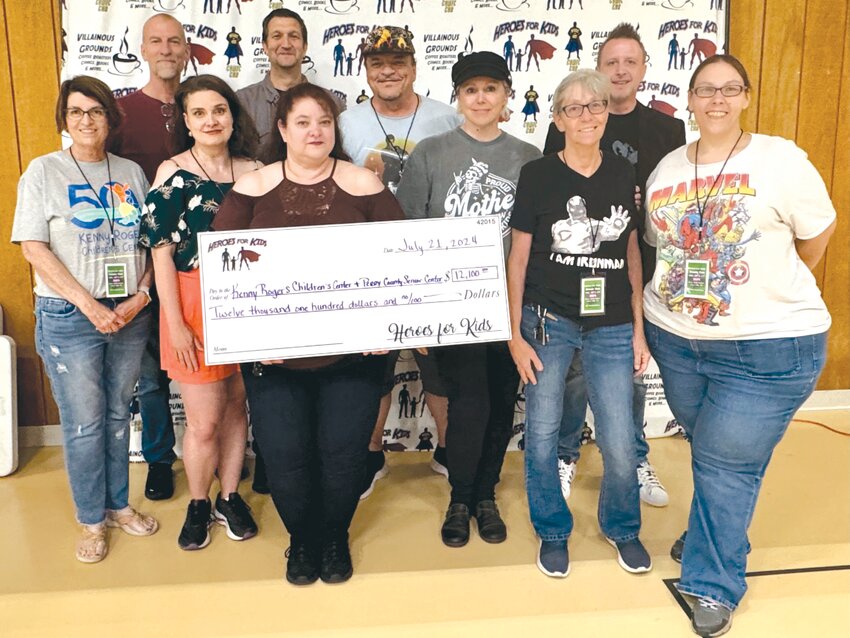 An oversized $12,100 check was presented to Michelle Fayette, the executive director of Kenny Rogers Children&rsquo;s Center (far left), Perry County Senior Center Activities Director Marlene Milam and senior center Meals on Wheels driver Amber Douglas (far right). Also pictured are Lonnie and Jess Johnson of the Heroes For Kids, Villainous Grounds owner Mary Jo Bammel and this year&rsquo;s Comic Con special guests: artist and actor Matthew Atchley, writer and podcast co-host Erin M. Evans, comic book artist Steve Geiger and character actor Marti Matulis.