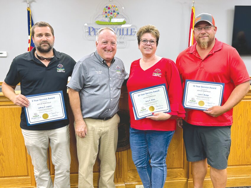 At the top of the July 16 Perryville Board of Aldermen meeting, Mayor Larry Riney (second from left) recognizes several employees for their years of service to the city. They are (from left) Jeff Layton, five years; Amy Webb, 25 years; and Lyle Mudge, 15 years.